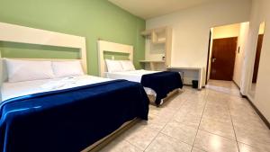 a bedroom with two beds and a door to a room at Oasis do Mar Hotel - A melhor vista de Itapema in Itapema