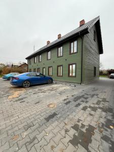 une voiture bleue garée devant un bâtiment dans l'établissement Green apartment, à Jelgava