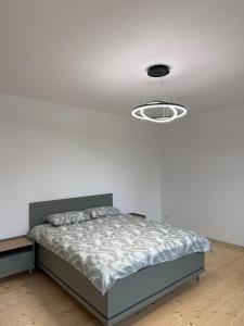 - une chambre blanche avec un lit et un éclairage dans l'établissement Green apartment, à Jelgava