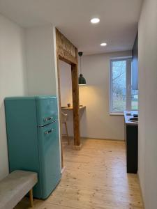a kitchen with a blue refrigerator in a room at Green apartment in Jelgava