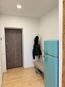 a room with a blue refrigerator and a door at Green apartment in Jelgava