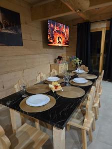 een lange tafel met stoelen en borden en een televisie bij Złoto Jedla in Białka Tatrzanska