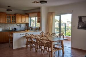a kitchen with a wooden table and chairs in a kitchen at Simply Holzer in Kinneret