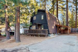 a black house in the woods with a porch at Charming Cabin in Bijou