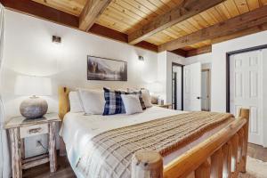 a bedroom with a large bed and a wooden ceiling at Charming Cabin in Bijou