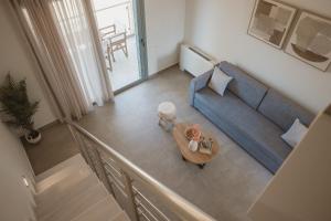 a living room with a blue couch and a table at QUERCUS Boutique Living in Valanidorachi