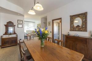 ein Esszimmer mit einem Tisch und einer Blumenvase darauf in der Unterkunft La Piazzetta in San Giovanni in Persiceto