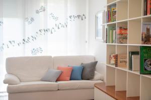 ein weißes Sofa mit bunten Kissen auf einem Zimmer in der Unterkunft La Piazzetta in San Giovanni in Persiceto