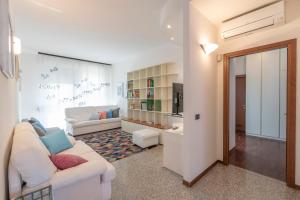 ein Wohnzimmer mit einem weißen Sofa und einem Fernseher in der Unterkunft La Piazzetta in San Giovanni in Persiceto + 3 Fotos