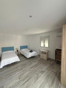 a bedroom with two beds and a wooden floor at Villa Atlantic Marquesa - Punta Umbria in Punta Umbría