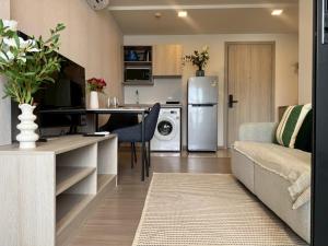 Work and Travel في كاتو: مطبخ وغرفة معيشة مع أريكة وثلاجة