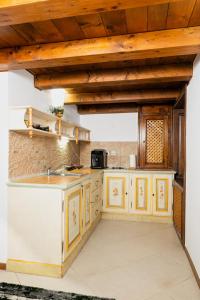 a kitchen with yellow cabinets and wooden ceilings at Baroque Residence in Timişoara