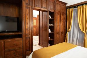 a bedroom with a bed and a tv and wooden cabinets at Baroque Residence in Timişoara