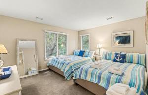 a bedroom with two beds and a mirror at 359 Tarpon Blvd in Fripp Island +55 photos
