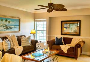 een woonkamer met twee banken en een plafondventilator bij 2BR Siesta Key Downtown Condo Walk Everywhere in Bailey Hall