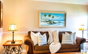 een woonkamer met een bank met kussens bij 2BR Siesta Key Downtown Condo Walk Everywhere in Bailey Hall