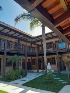 una persona sentada en un banco frente a un edificio en Pousada Baleia Franca, en Garopaba