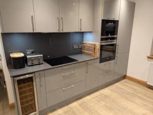 a kitchen with white cabinets and a stove top oven at Royal Gardens Apartment 10 in Dornoch