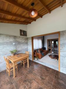 un soggiorno con un tavolo di legno e un divano di Le Ronde Elysée a Piranguçu