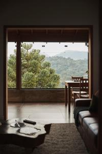 un soggiorno con una grande finestra e un tavolo di Le Ronde Elysée a Piranguçu