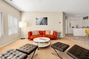 パーム・スプリングスにあるVista-Verdeのオレンジ色のソファとテーブルのあるリビングルーム +35枚の写真