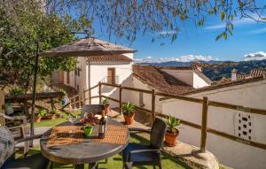 Un patio con una mesa y sillas y una sombrilla. en Impresionante casa molino, en Benadalid