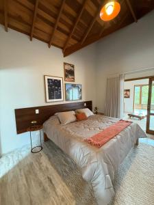 una camera da letto con un letto grande in una stanza di Le Ronde Elysée a Piranguçu