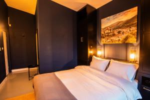 una camera da letto con un letto grande con un dipinto sul muro di Off-Site Stay 