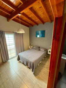 Un dormitorio con una cama y un techo de madera. en Departamentos Norte 2, en Villa Gesell