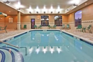 una piscina en un hotel con sillas y mesas en Staybridge Suites Rochester University by IHG, en Rochester