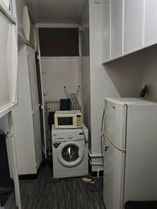 a kitchen with a washing machine and a microwave at Studio chambre salon cuisine in Dakar