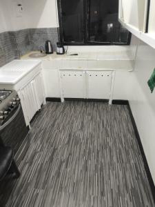 a kitchen with white cabinets and a large window at Studio chambre salon cuisine in Dakar +6 photos