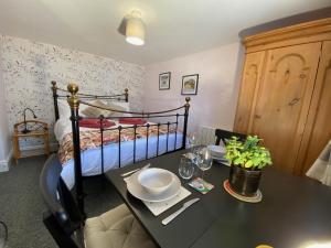 Cygnet Studio في Dingestow: غرفة طعام مع طاولة وسرير