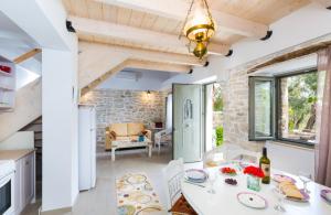 Olive Cottage في Petrátika: مطبخ وغرفة طعام مع طاولة وكراسي