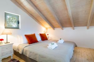 Olive Cottage في Petrátika: غرفة نوم بها سرير عليه منشفتان