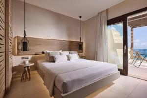 una camera da letto con un letto grande e un balcone di Melitina a Sitia Altre 32 foto