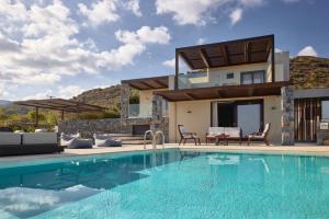 una villa con piscina di fronte a una casa di Melitina a Sitia