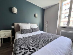 een slaapkamer met een bed met een zwart-wit dekbed bij Le Clos de Manon in Carcassonne