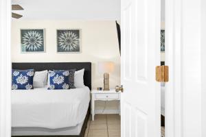 een slaapkamer met een bed en een nachtkastje met een tafel bij Sun Baker II South in Anna Maria Island