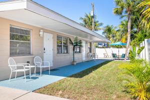 een huis met stoelen en een veranda met palmbomen bij Sun Baker II South in Anna Maria Island