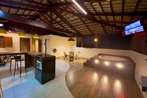 a large room with a kitchen and a living room at Cobertura Jacuzzi e Area Gourmet Sao Judas in Divinópolis