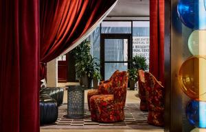 ein Zimmer mit zwei Stühlen und einem Vorhang in der Unterkunft The Radical Asheville, Tapestry Collection by Hilton in Asheville
