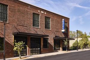 阿什维尔The Radical Asheville, Tapestry Collection by Hilton的上面有蓝色标志的红砖建筑