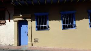 a building with a blue door and two windows at Candelaria House Boutique in Bogotá