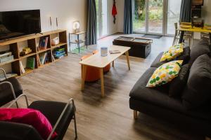 a living room with a couch and a coffee table at Appartement rétro nature avec jardin 15 min Toulouse centre in Saint-Geniès-Bellevue