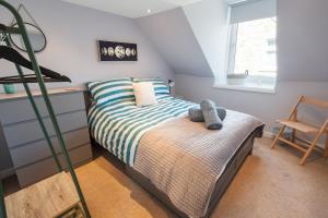 a small bedroom with a bed and a chair at Charming 2 bed in Aberchirder in Aberchirder