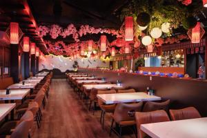a row of tables in a restaurant with pink lights at Aiden Austin City Hotel in Austin