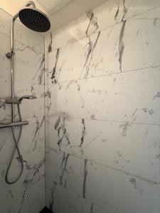 een badkamer met een witte marmeren muur bij Studios 4 nations in Épinal
