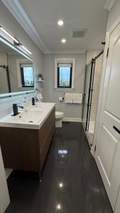 a bathroom with a sink and a toilet and a mirror at Modern Retreat with Hot tub by YYZ, 20min to CN Tower in Toronto