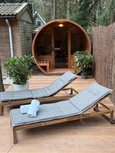 due sedie a sdraio su un ponte con gazebo di Forest house with sauna a Norg